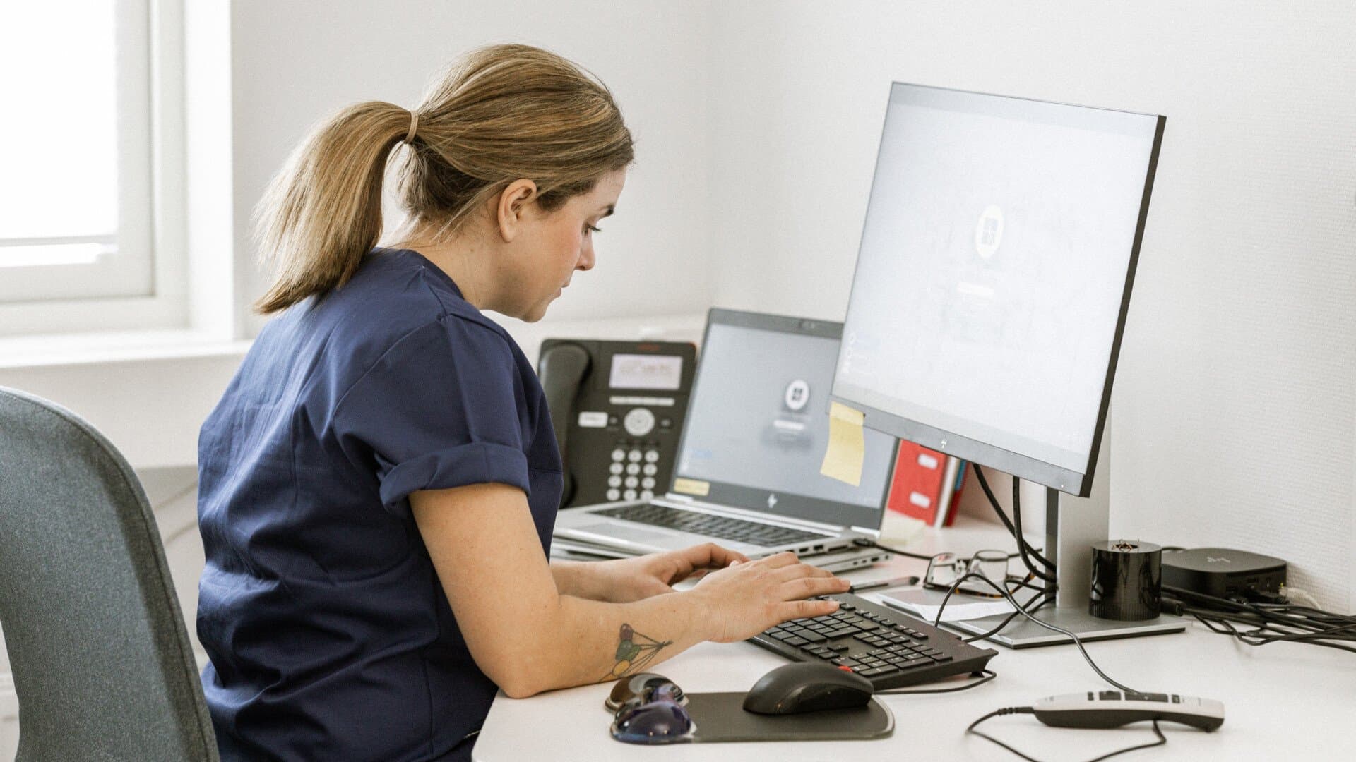 Sjuksköterska sitter vid dator