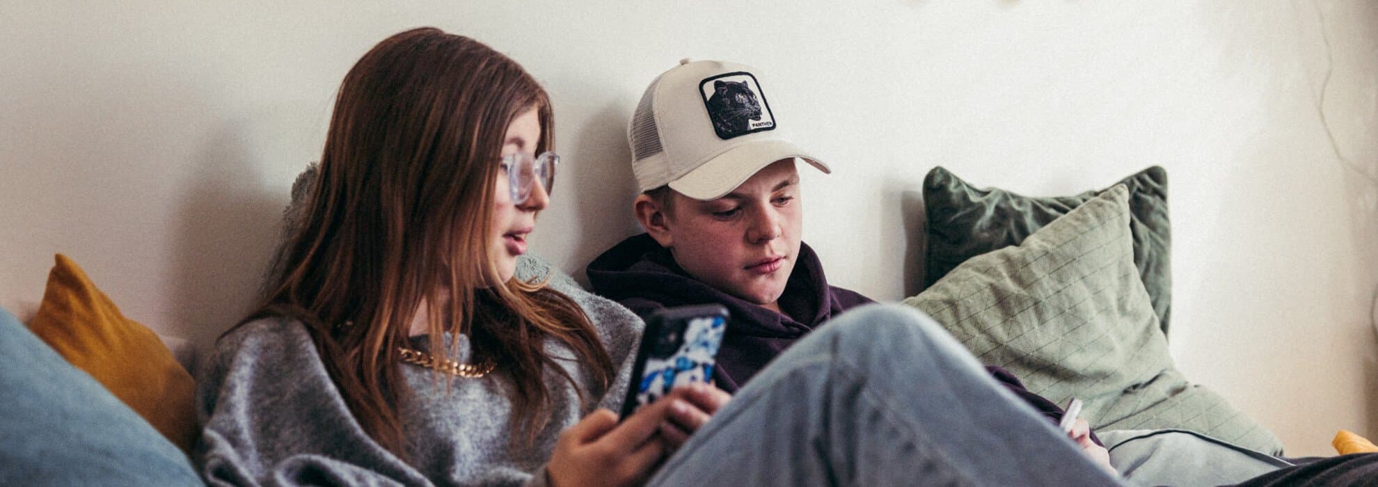 Tjej och kille i tidig tonår kollar mobil. Tjej och kille i tidig tonår kollar mobil.