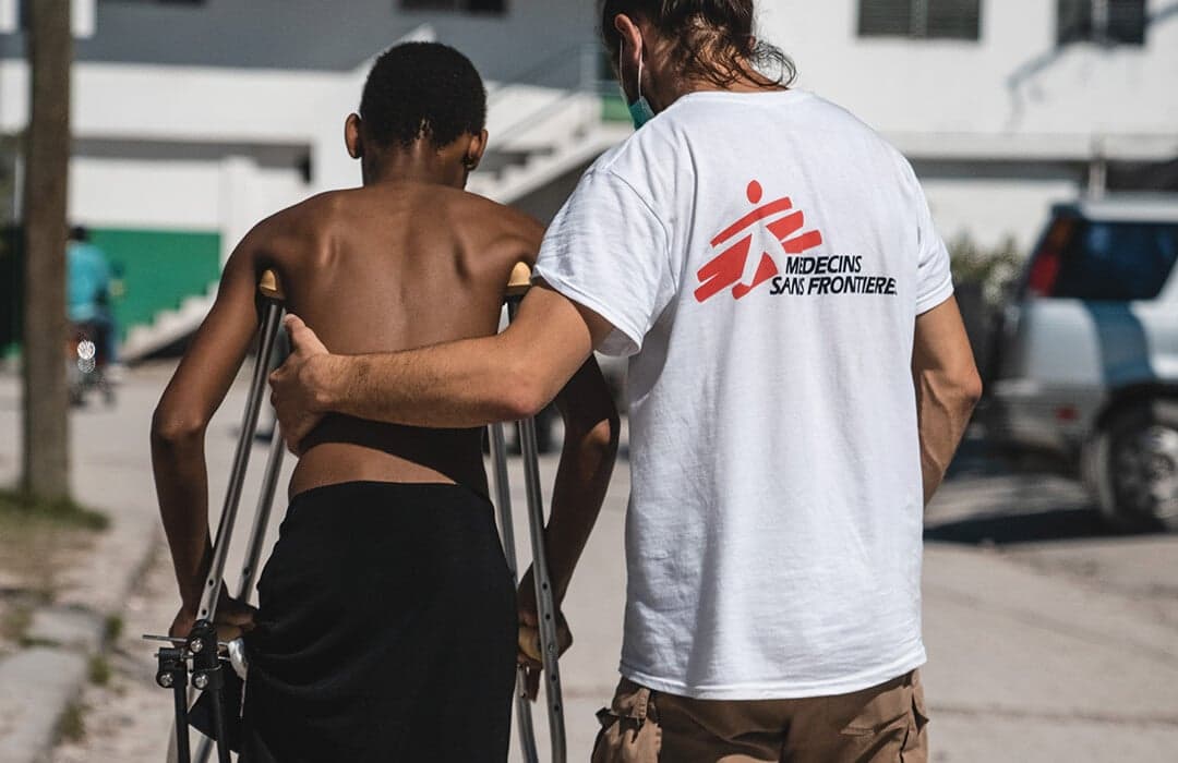 läkare hjälper ett barn på kryckor