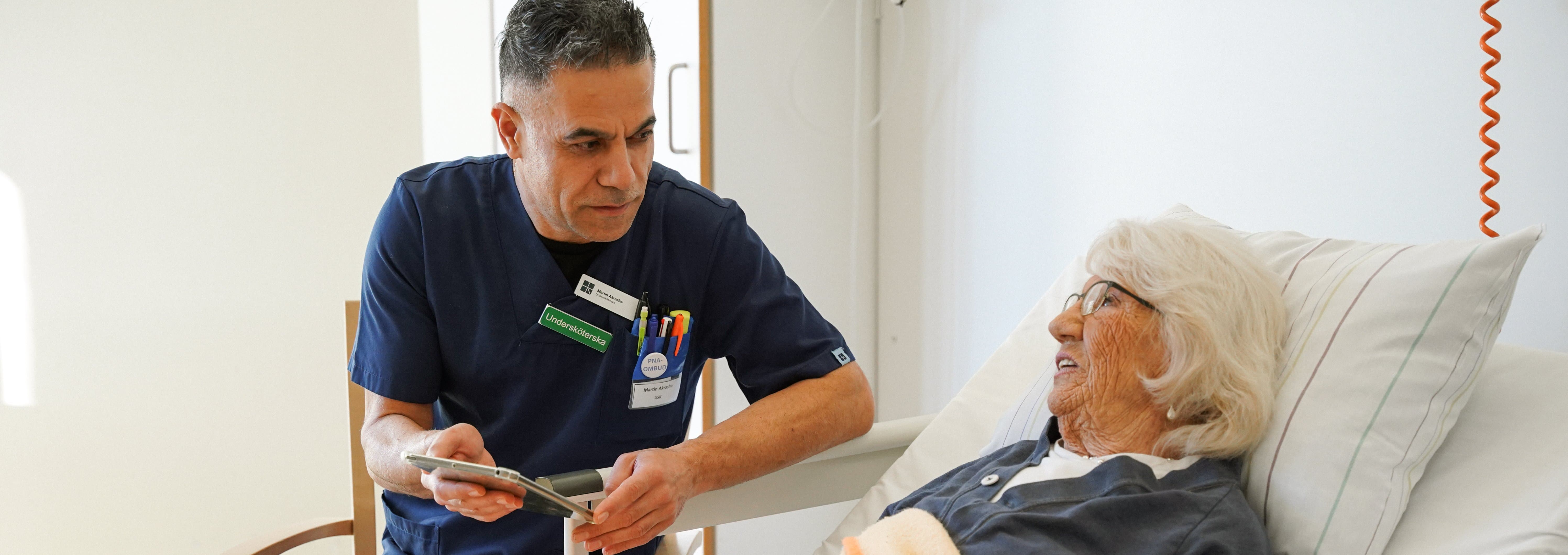 Undersköterska och patient i sjuksäng